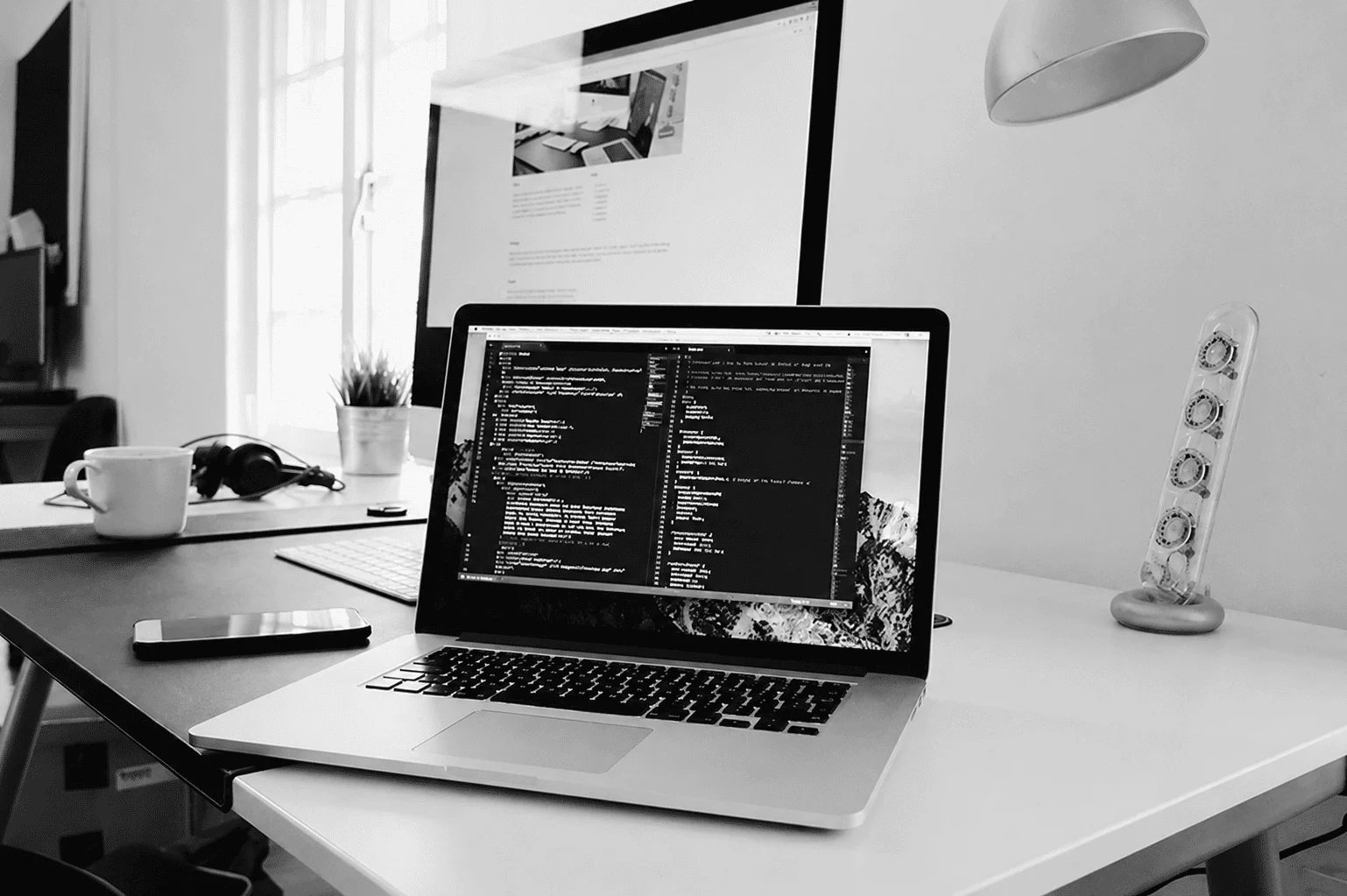 Laptop displaying code on a modern office desk