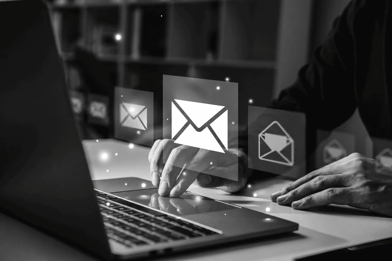Person using laptop with floating email envelope icons